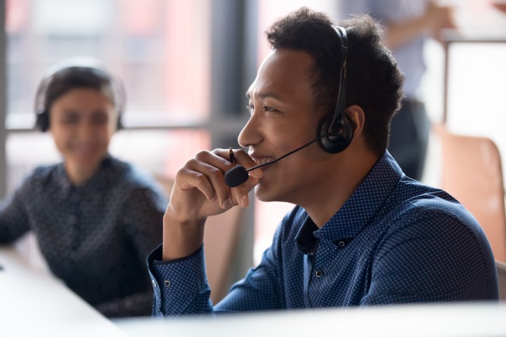 Young male managed IT service provider talking to a client on the phone.