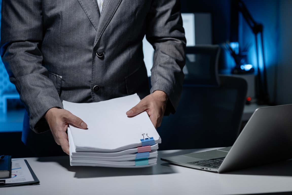 An employee was tidying up a pile of documents piled on his desk