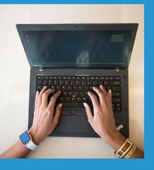 Hands typing on a Lenovo ThinkPad laptop viewed from above.